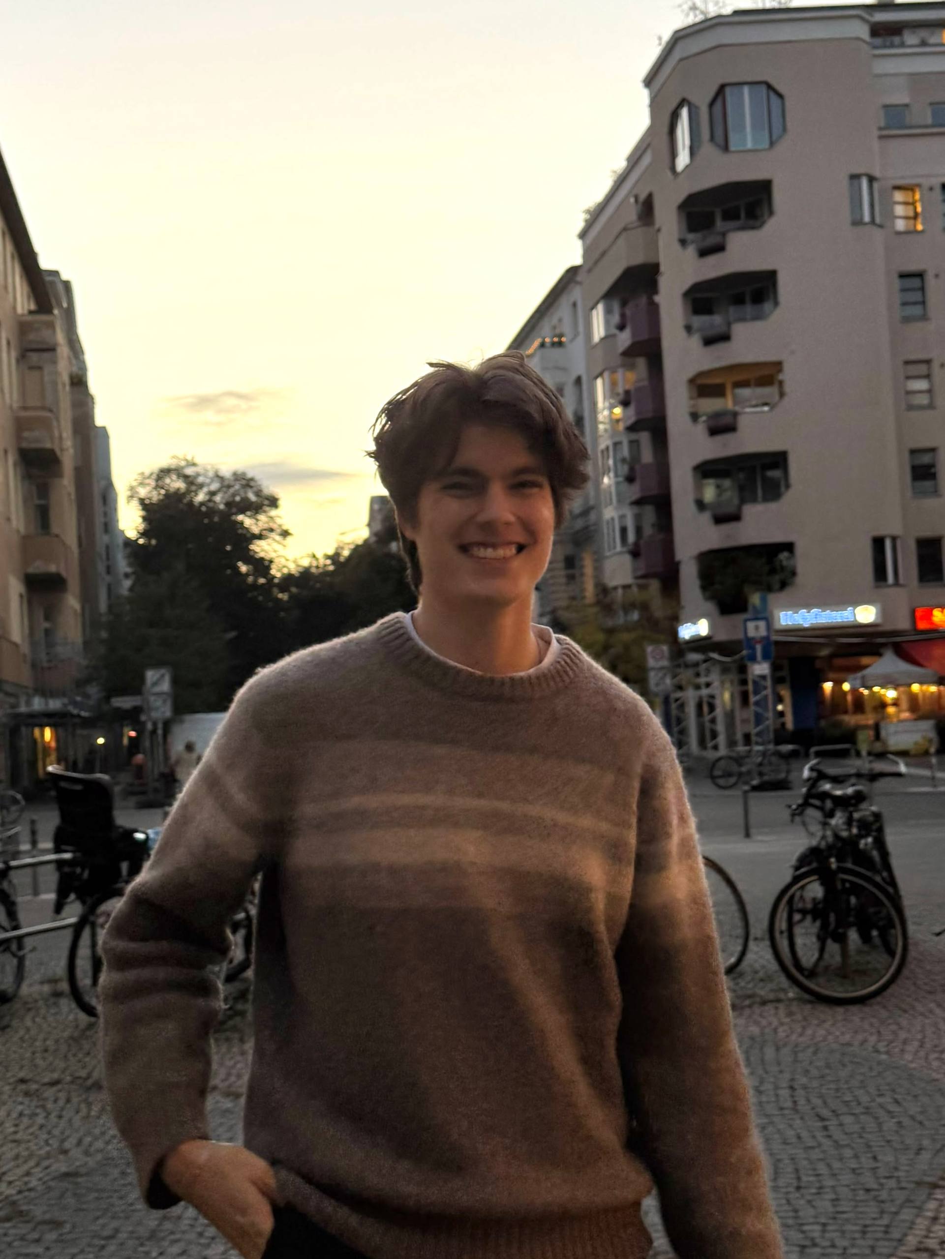 Ben Friedel smiling outdoors in a gray sweater